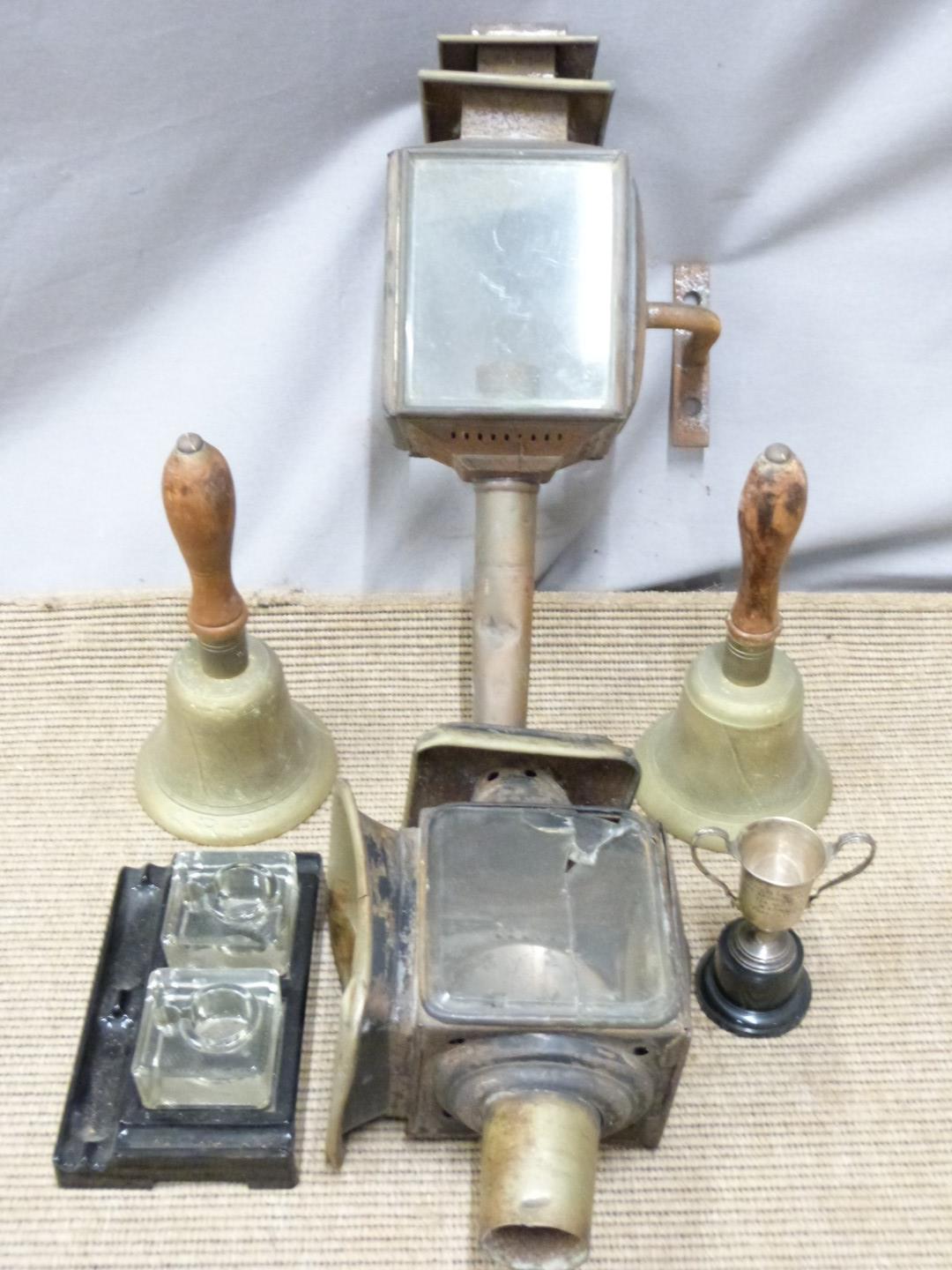 Two brass ARP bells, coaching lamps, Standish, and a hallmarked silver trophy, tallest 52cm