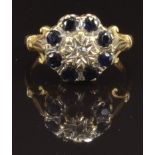 An 18ct gold ring set with a diamond surrounded by sapphires, size P, 5.1g