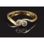 An 18ct gold ring set with two diamonds in a twist setting, size O, 2.1g