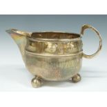 A E Jones Arts & Crafts jug with hammered and embossed decoration, Birmingham 1924, length 13cm,