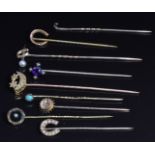 Two Edwardian 9ct gold stick pins in the form of horseshoes, a Victorian 9ct gold stick pin set with