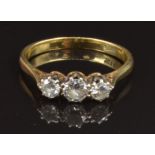 An 18ct gold ring set with three diamonds, the centre stone approximately 0.25ct, size P, 2.9g