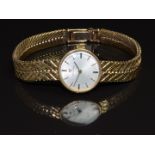 Omega 9ct gold ladies wristwatch with black hands, black and gold baton hour markers, silver dial