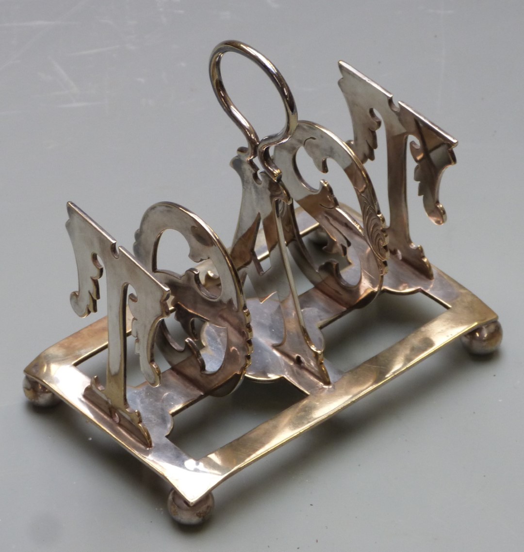 Silver plated toast rack with the bars formed as the word toast, length 12cm