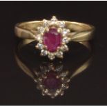 A 9ct gold ring set with an oval ruby surrounded by diamonds, size K, 2.2g