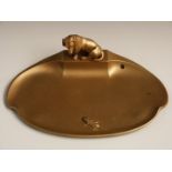 Gilded dish with figural decoration of a Dachshund staring at a lizard, width 23cm