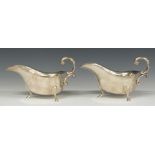 Pair of modern hallmarked silver gravy boats, raised on three feet, Birmingham 1975, maker