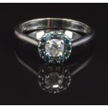 An 18ct white gold ring set with a diamond of approximately 0.25ct surrounded by blue diamonds, size