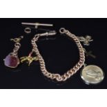 A 9ct rose gold charm bracelet with four 9ct gold charms including shamrock, cross, horse and a