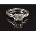 A white metal ring set with four square cut diamonds surrounded by round cut diamonds, size J, 2.1g