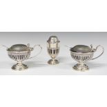 George V hallmarked silver three piece cruet set with blue glass liners and pierced bodies