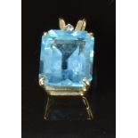 A 9ct gold pendant set with an emerald cut blue topaz and a diamond, 2g