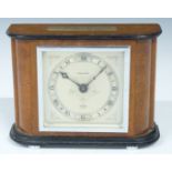 Elliot mantel clock with Kendal & Dent to silvered engraved Roman dial, the wooden case with