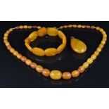 An amber necklace of 47 oval beads, amber bracelet and faux amber pendant