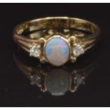 A 9ct gold ring set with an opal and two diamonds, size N, 2.6g