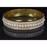 Victorian gold bangle set with a central row of split pearls flanked by two rows of seed pearls,