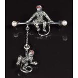 A silver brooch in the form of two monkeys, set with marcasite and pearls