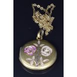 A yellow metal c1900 locket set with seed pearls and rubies in a floral design, 2.8cm, 7.8g