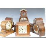 Six C1920-1930 mantel clocks and a 1970s cuckoo wall clock, includes a drum cased Wurttemberg
