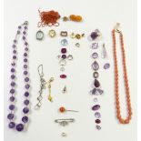 A collection of gemstones including amethyst, garnet, citrine, coral necklace, saphirite,