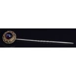 Victorian 15ct gold stick pin set with a garnet cabochon, 8.4cm long