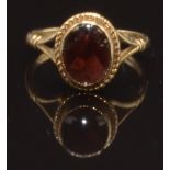 A 9ct gold ring set with an oval garnet, size O, 2.9g