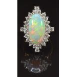 An 18ct gold ring set with a large oval opal cabochon of approximately 4ct surrounded by 24 round