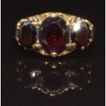 A 9ct gold ring set with three oval cut garnets, size L, 4g