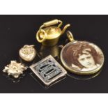 A 9ct gold locket, yellow metal kettle charm, 9ct gold heart charm, 2.1g, and a 9ct gold and