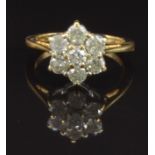 An 18ct gold ring set with seven round cut diamonds in a flower cluster, total diamond weight