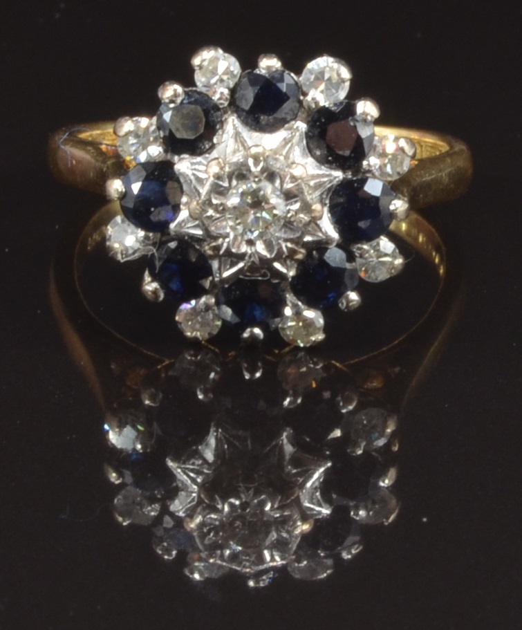 An 18ct gold ring set with diamonds and sapphires in a cluster, size M, 5.4g