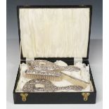 Cased hallmarked silver four piece dressing table set with embossed decoration