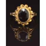 A 9ct gold ring set with an oval garnet within a twisted border, size I, 2.6g