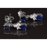 A pair of 18ct white gold earrings set with two oval cut sapphires and three diamonds to each, 3g