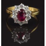 An 18ct gold ring set with an oval cut ruby of approximately 0.9ct surrounded by ten round cut