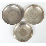Three coin based pin dishes, one with feature hallmarks the other two unmarked, diameter of