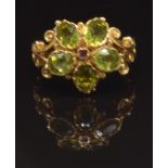 A 9ct gold ring set with a ruby surrounded by peridot in a flower cluster, size N, 4.1g