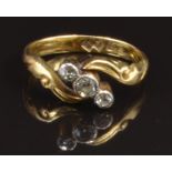 An 18ct gold ring set with three diamonds in a scrolling twist setting, size G, 2.7g