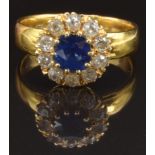 A 22ct gold ring set with a cushion cut sapphire of approximately 0.65ct surrounded by old cut