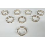 Set of eight Eastern white metal napkin rings, four decorated with animals and four with flowers,