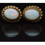 A pair of 9ct gold earrings set with an opal to each, 1.5g