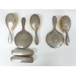 Two hallmarked silver dressing table sets, one comprising hand mirror and two pairs of brushes,