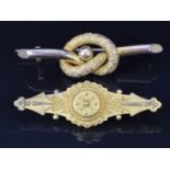 A 9ct gold love knot brooch (2.2g) and a Victorian Etruscan Revival 15ct gold brooch with glass