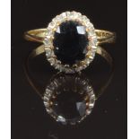 A 9ct gold ring set with an oval cut sapphire surrounded by diamonds, size M, 2.5g