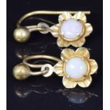 A pair of yellow metal earrings set with an opal to each