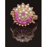 A yellow metal ring set with round cut rubies and seed pearls in a cluster, size K, 4.3g