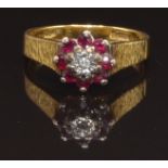 An 18ct gold ring set with a diamond surrounded by rubies, size M, 3.9g