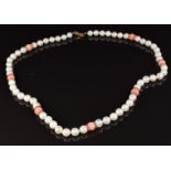 A single strand cultured pearl and coral necklace with a 9ct gold clasp and dividers, in Mikimoto
