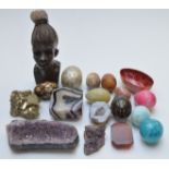 A section of amethyst and agate geodes, carved stone African head, eggs, etc