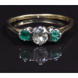 An 18ct gold ring set with an old cut diamond of approximately 0.26ct and emeralds, size M, in